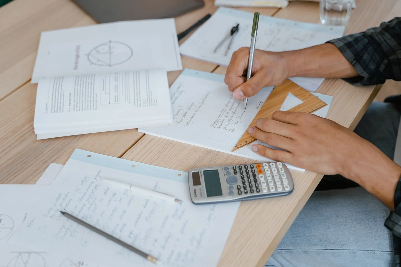 Ev ortamında masada matematik problemi çözen öğrenci